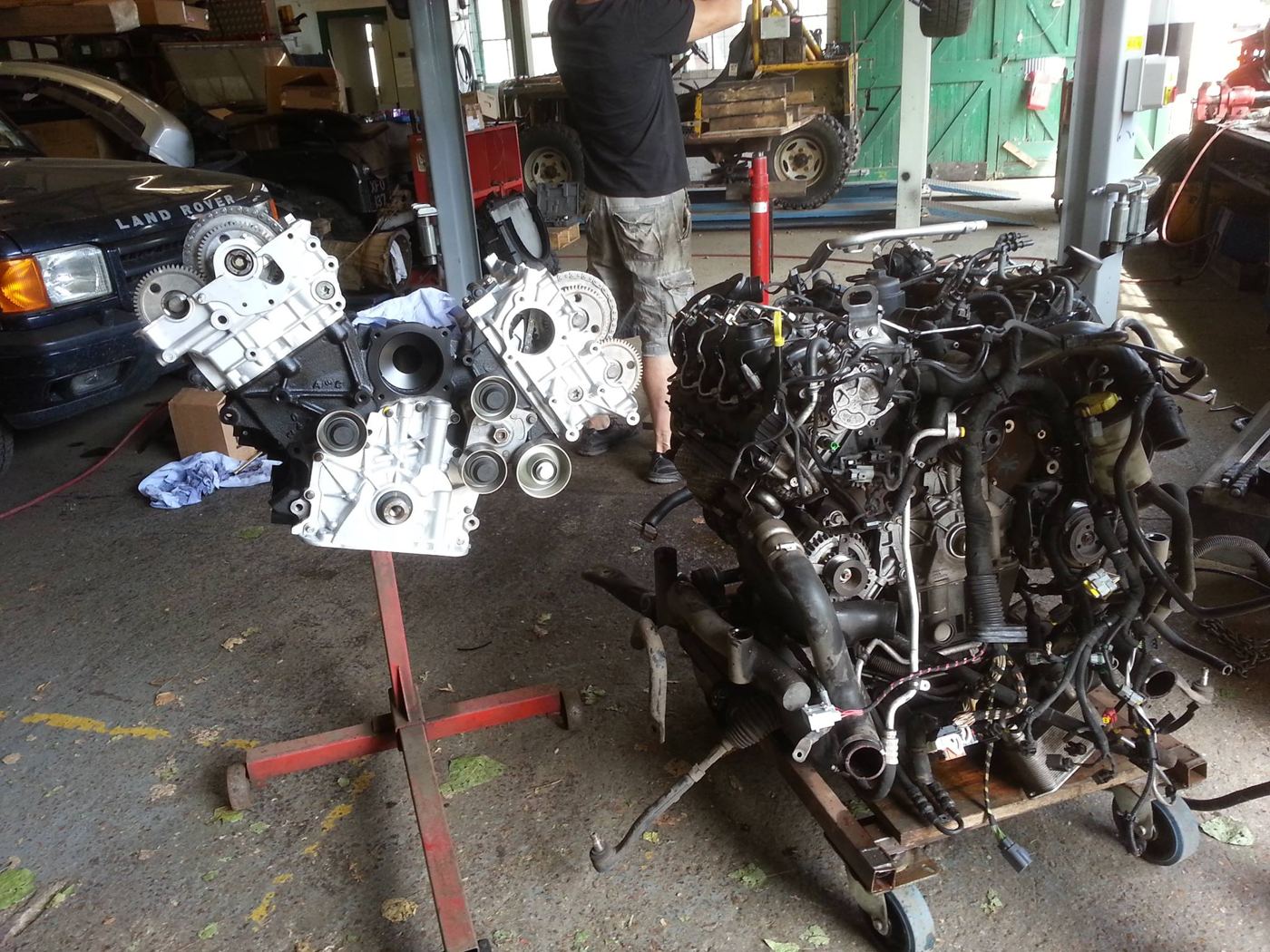 Reconditioned V6 diesel engine on a stand next to the original