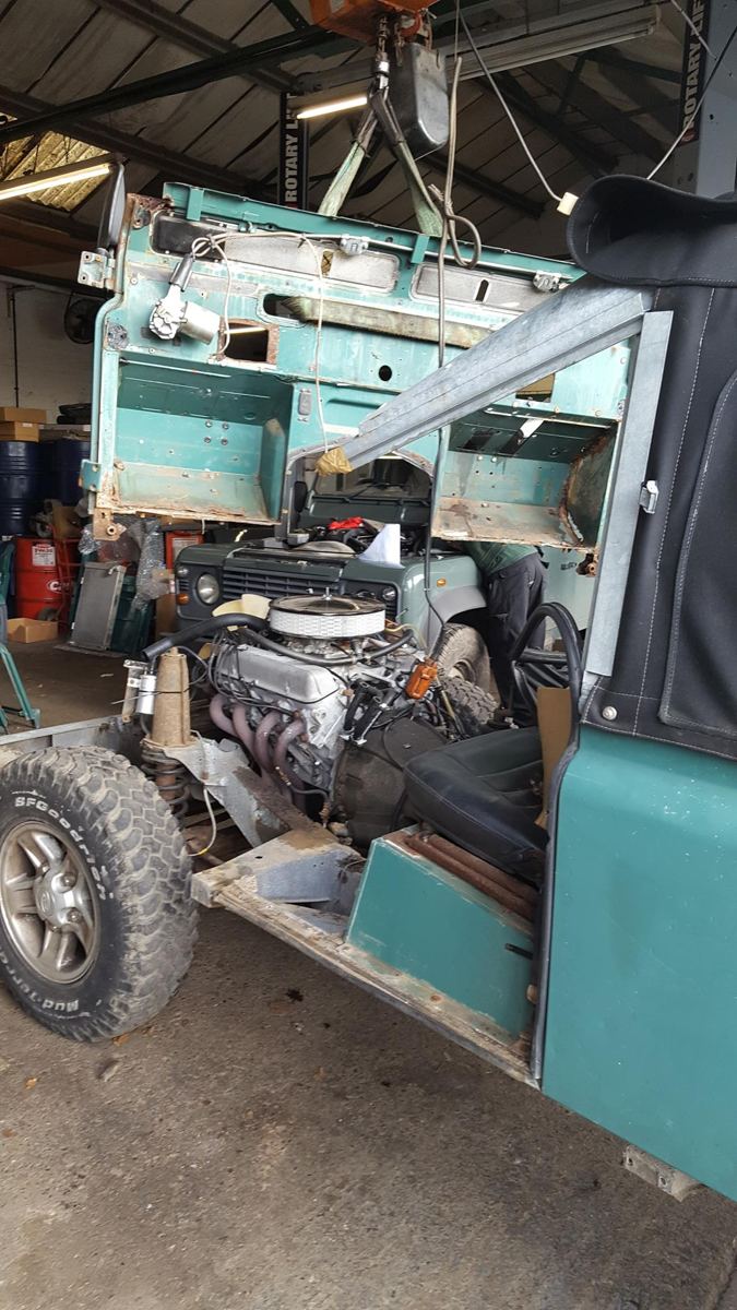 Bulkhead lifted on the hoist above a V8-engined Land Rover